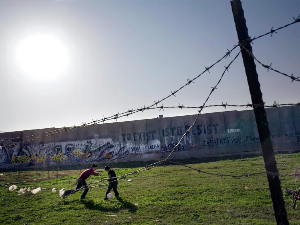 Foto: Markus Marcetic Två barn spelar fotboll framför muren i Palestina
