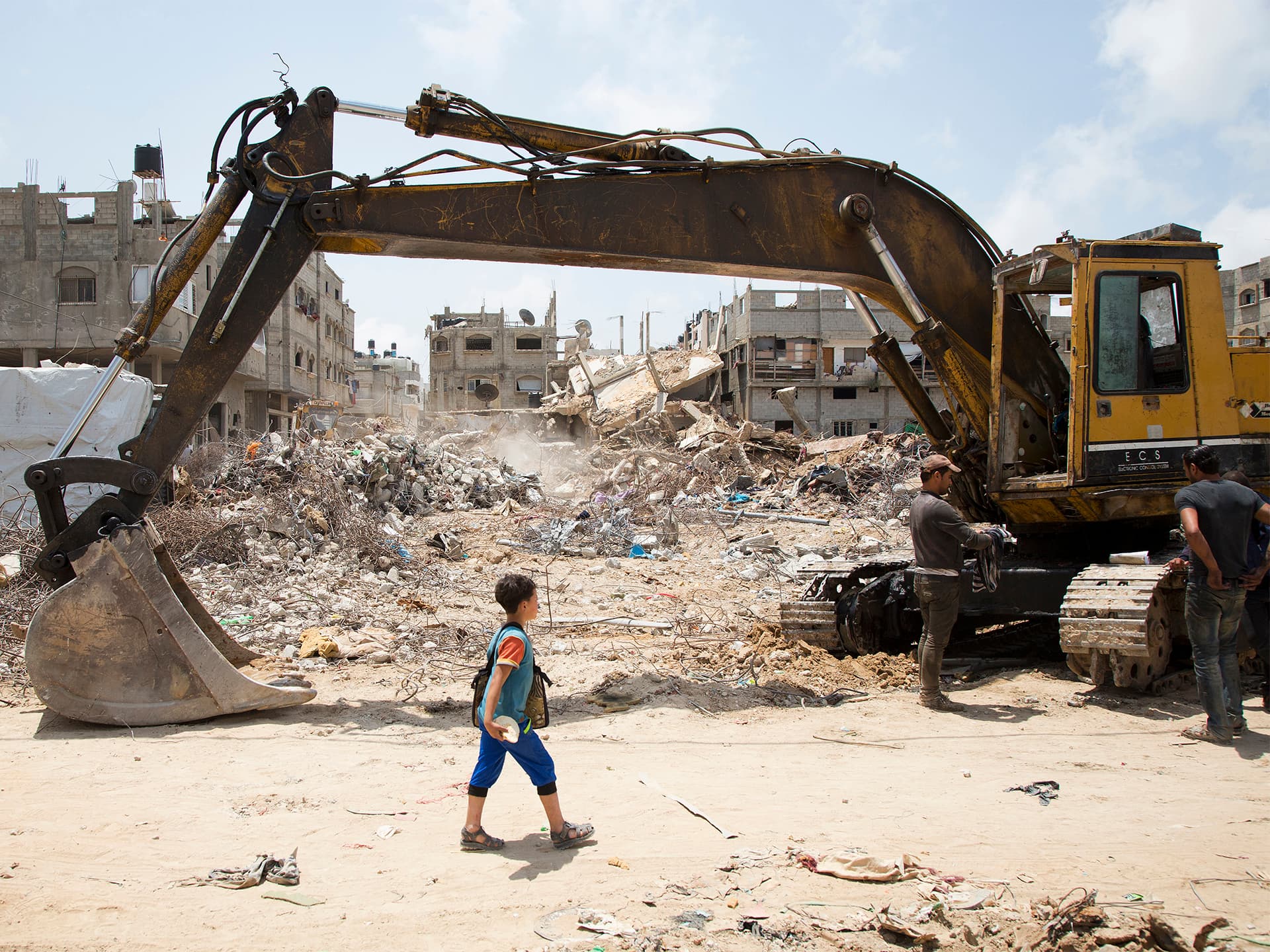 Foto: Claes Herrlander Pojke framför ruiner och grävskopa i Gaza